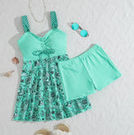 Two-piece swimsuit with turquoise bandeau top, polka-dot straps, and patterned skirt