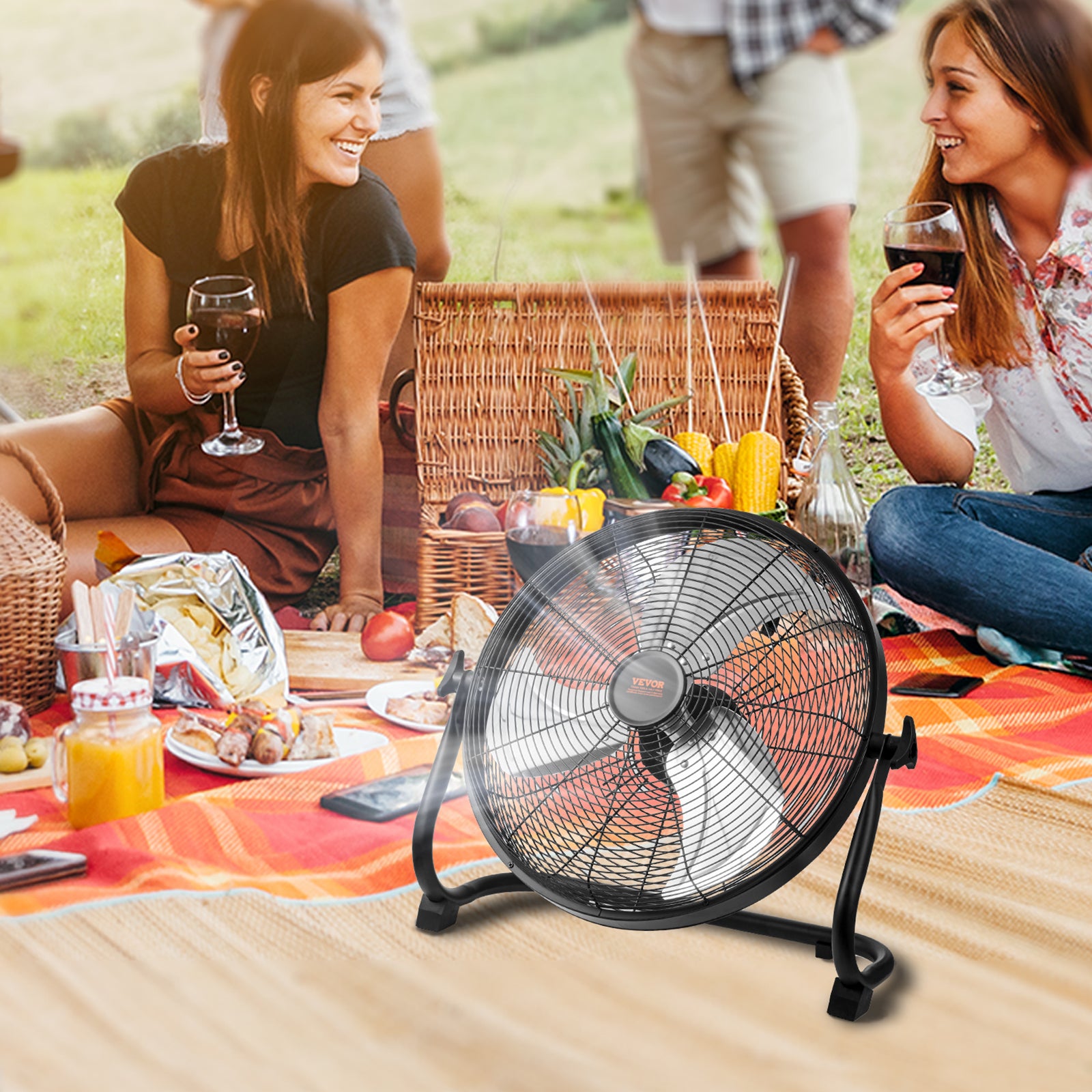 Portable floor fan with black wire grille and arched legs, outdoors on a picnic table.