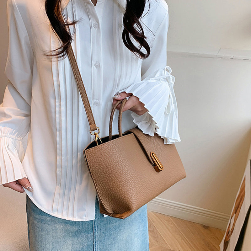 Beige textured PU bucket tote bag with front zipper and top shoulder strap.