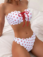 White printed tube-top bikini with red hearts, tie-front drawstring, scalloped high-waist briefs