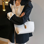 White textured PU bucket tote bag with front zipper and gold-tone hardware.