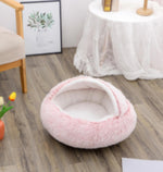 Round pink plush pet bed with thick edge and hollow interior for pets