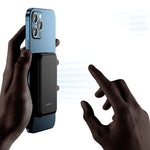 Black magnetic wireless power bank attached to a smartphone, side ports visible