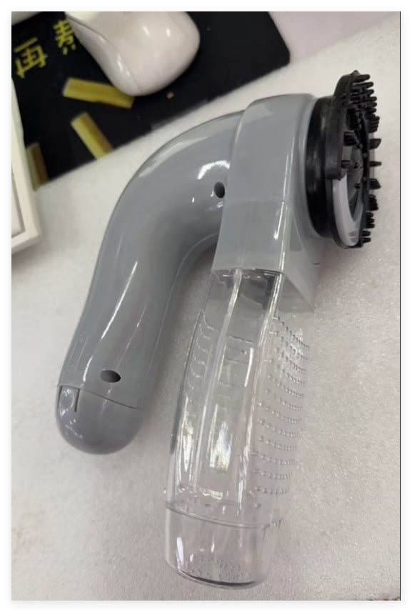 Portable pet hair vacuum cleaner close-up of grey handle and clear collection chamber