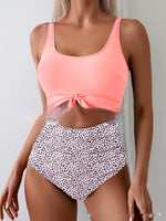 Pink one-piece swimsuit with tie-front waist and white dotted high-waist bottoms