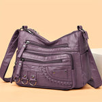 Purple soft PU leather crossbody bag with front zips, braided trim, and adjustable strap