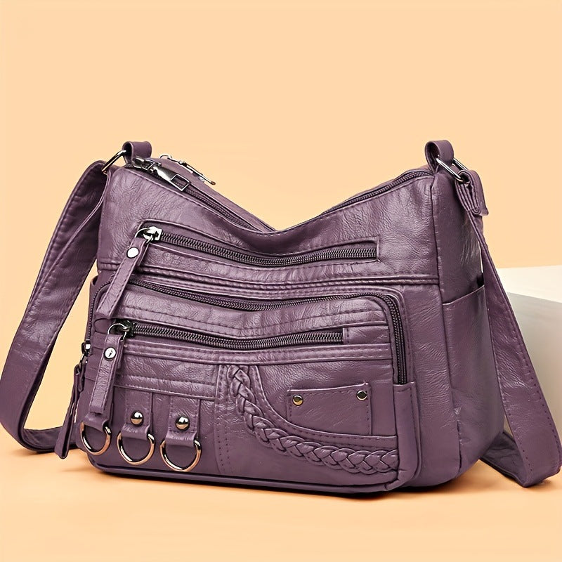 Purple soft PU leather crossbody bag with front zips, braided trim, and adjustable strap
