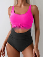 Pink one-piece swimsuit with tie-front waist and contrast black high-waist bottom
