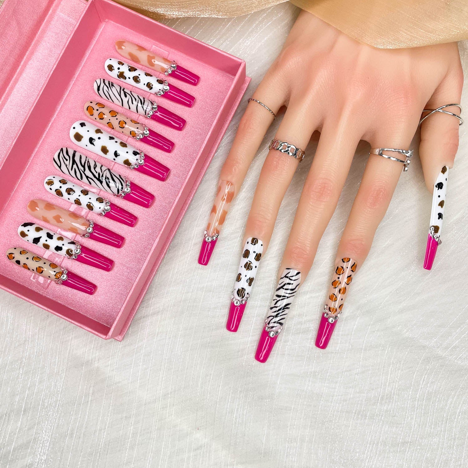 Stiletto press-on nail set in pink tray with zebra, leopard, and rhinestone details
