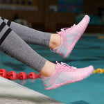 Pink water shoes with lace-up front and teal pattern detailing on the foot.