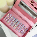 Pastel galaxy press-on nails displayed in an open box, covered with iridescent 3D crystals