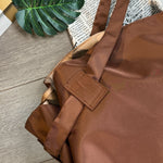 Brown Oxford cloth messenger bag close-up of padded handle and reinforced seams