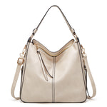 Beige hobo bucket bag with zipper top and side tassel details