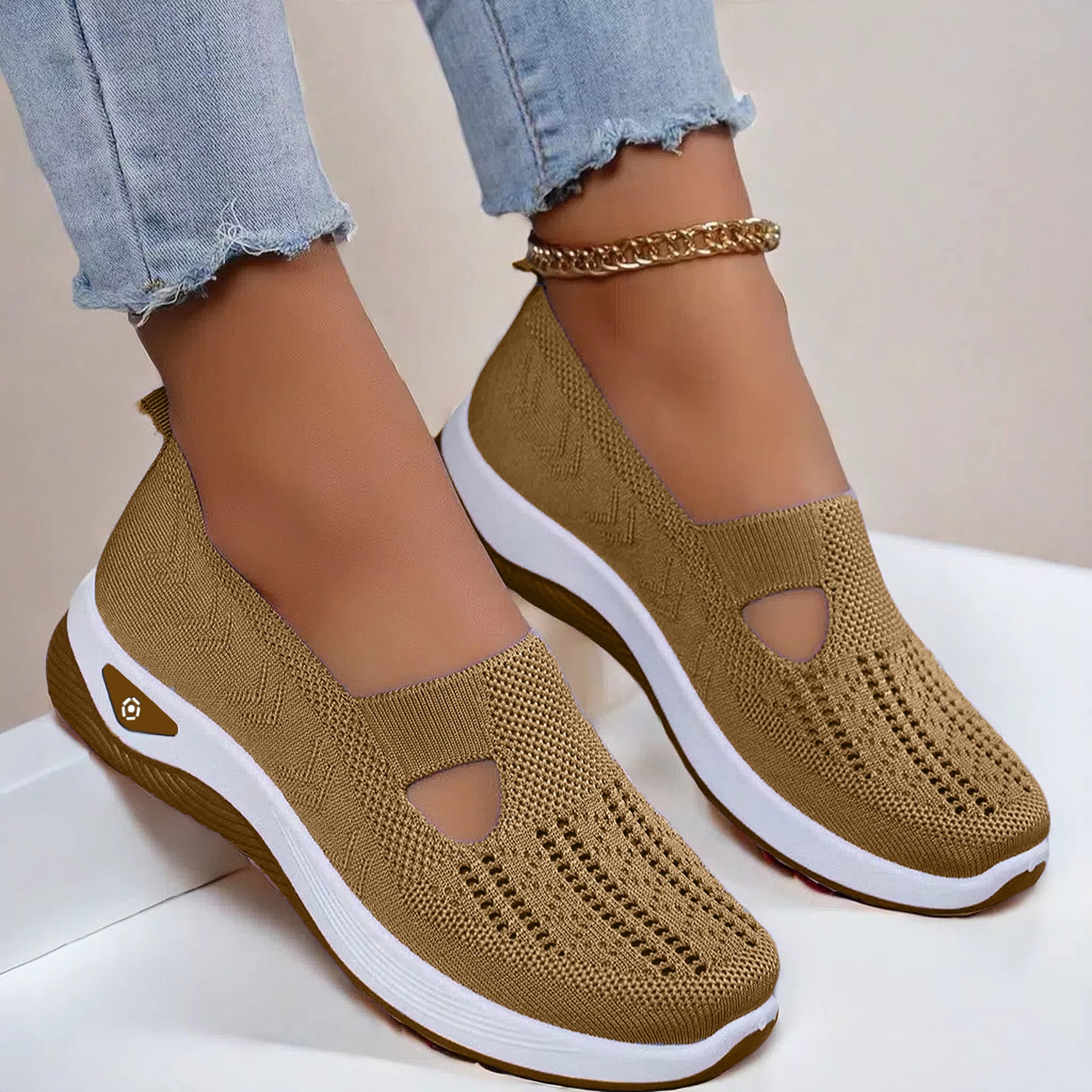Tan mesh slip-on flat shoes with oval cutouts and white cushioned soles